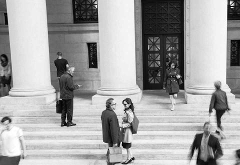 people standing on stone steps in front of a building with columns